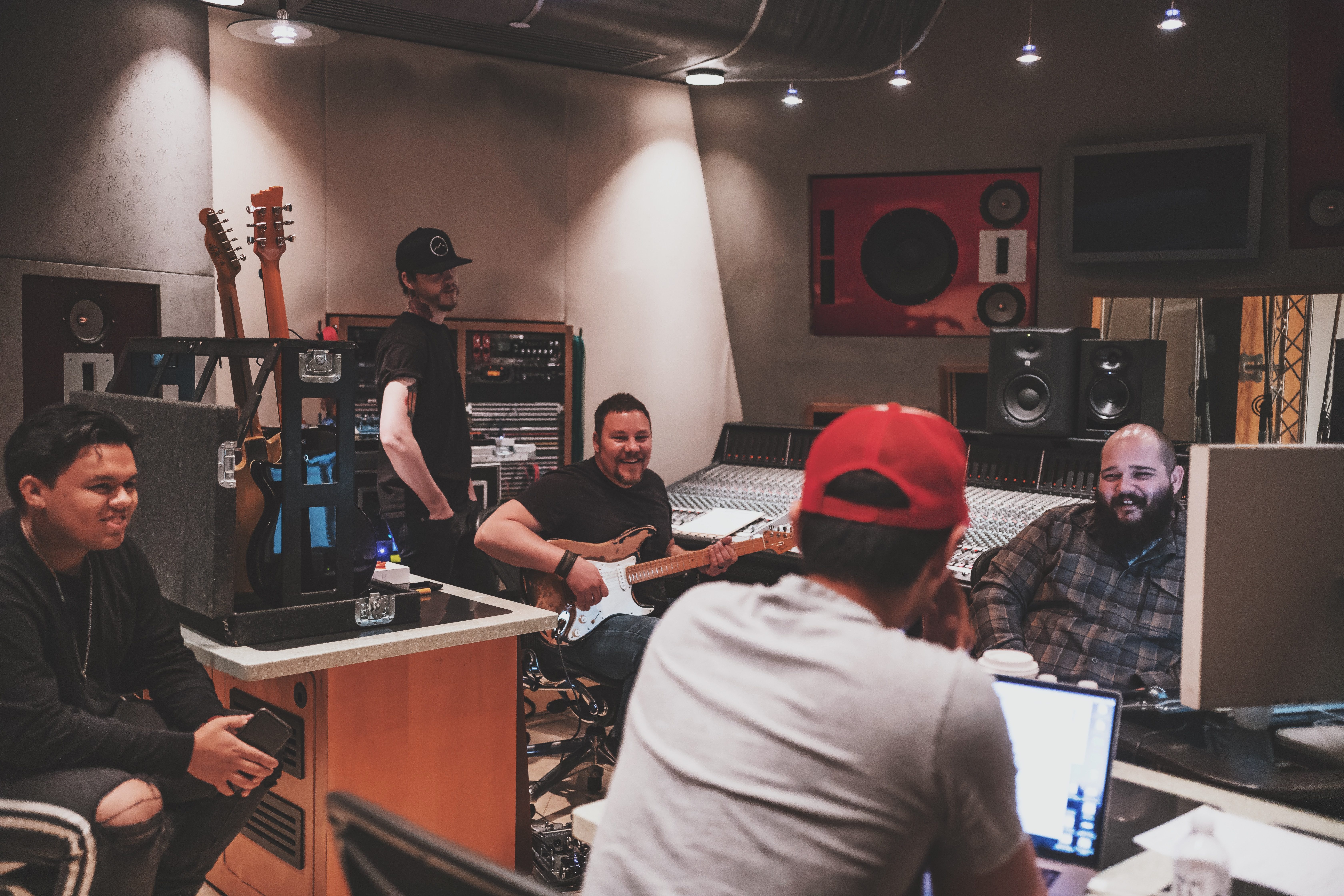 men gathering inside recording studio laughing